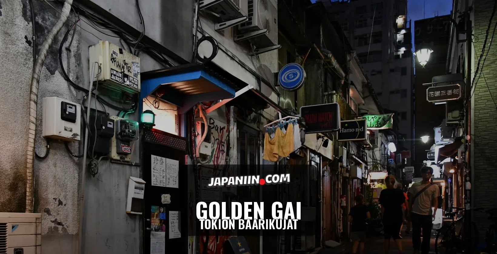 Golden Gai — Tokion baarikujat: kapea Golden Gain baarikuja Shinjukussa iltahämärässä, valokylttejä ja kujalla käveleviä ihmisiä