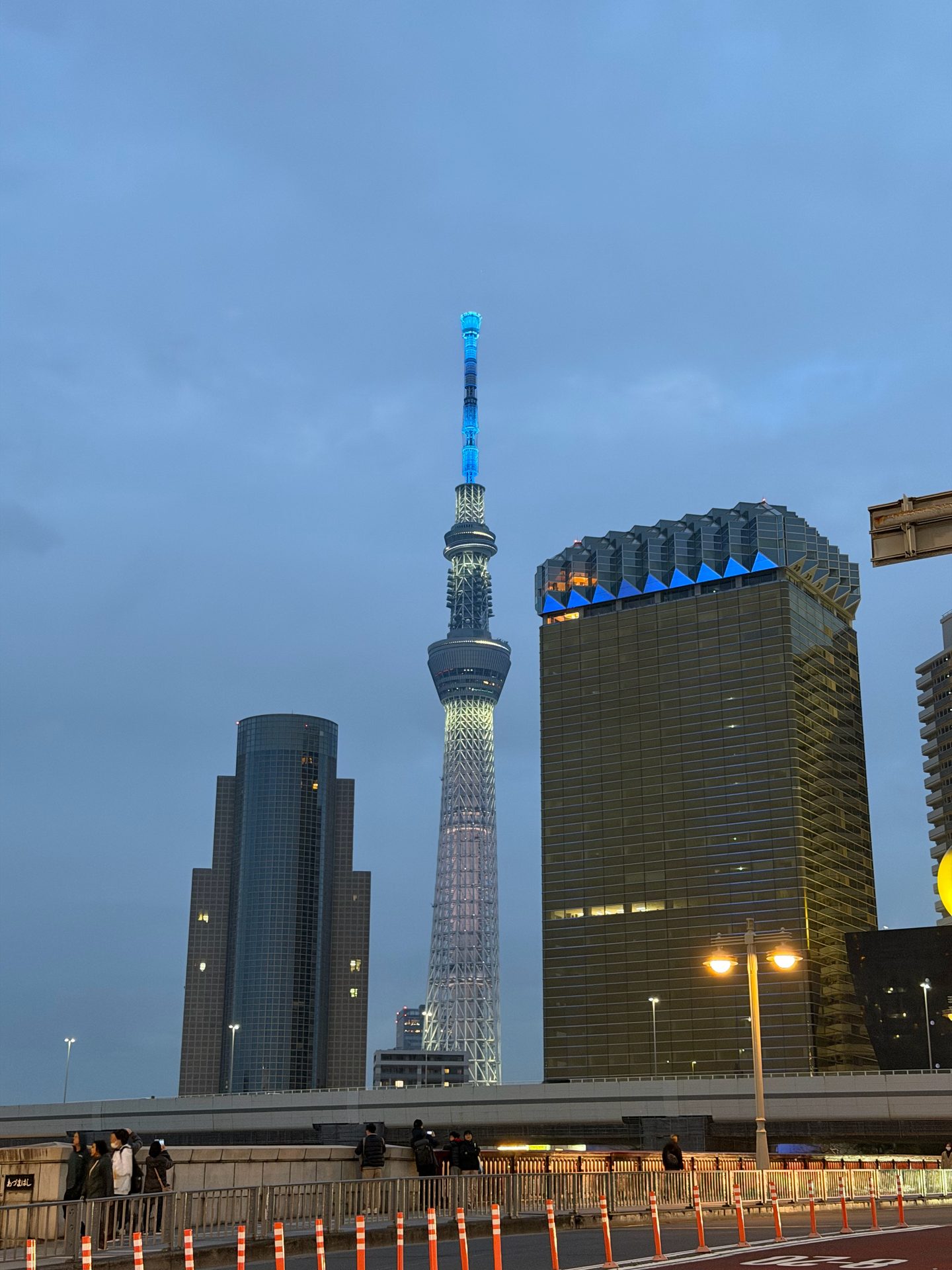 Tokyo Skytree illalla sinisenä valaistuna Sumida-joen rannalta